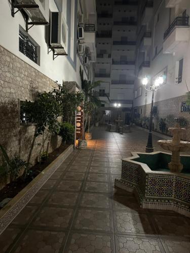 an empty alley with a fountain in a building at night at Ibtissam luxury residence in Larache