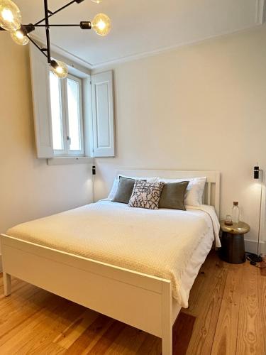 a bedroom with a white bed with a window at Santa Justa Cozy Room in Lisbon