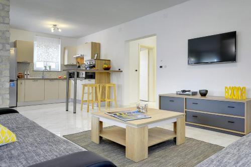 a living room with a couch and a table and a kitchen at Villa Rudy in Štinjan