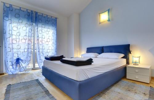 ein blaues Bett in einem Zimmer mit Fenster in der Unterkunft Holiday Home Baldini in Banjole