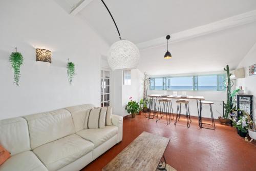 un salon avec un canapé blanc et une table dans l'établissement 3 Pièces avec Vue sur le Bastion, à Menton