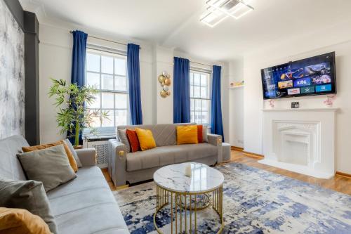 a living room with a couch and a fireplace at Luxury flat Next to Hyde Park & Oxford Street in London