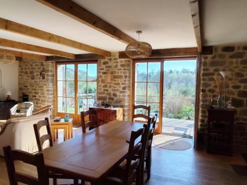 une salle à manger avec une table et des chaises en bois dans l'établissement Longère Coeur Bretagne, à Le Croisty