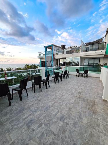 a patio with chairs and tables and a building at Casa Playa Boquilla in Cartagena de Indias