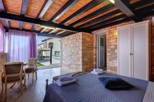 a bedroom with a bed and a brick wall at Villa Paradiso in Rovinj