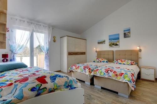 sypialnia z dwoma łóżkami i oknem w obiekcie Holiday Home Veronika w mieście Vinkuran