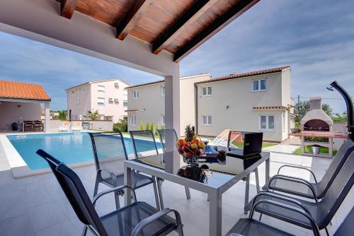 a patio with a table and chairs and a pool at Villa Marcelia in Pula