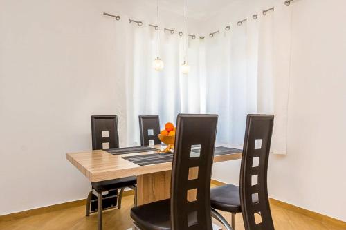 a dining room with a wooden table and chairs at Villa Marcelia in Pula