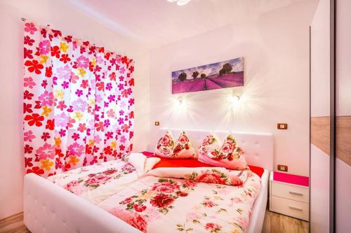 a small bedroom with a bed with a flowery wallpaper at Villa Marcelia in Pula