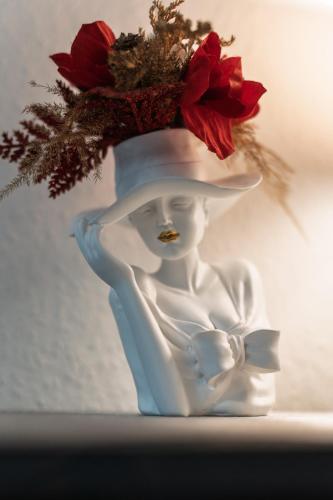 a statue of a woman with a hat and flowers at NEW Gästehaus Flora,Kitchen,TV,Free Parking,near Europa Park and Strasbourg in Hohberg