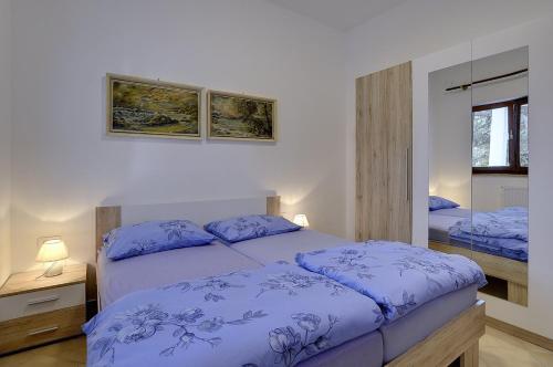 a bedroom with a bed with blue sheets and a mirror at Villa Mima in Banjole