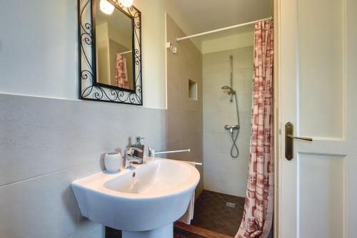 a bathroom with a sink and a mirror and a shower at Villa Oliva in Krnica