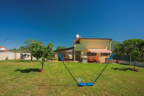 a yard with a swing in front of a house at Casa Sandi in Pula
