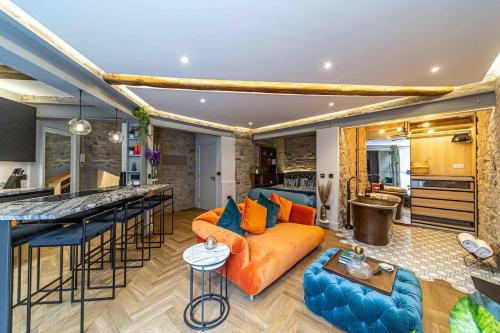 a living room with an orange couch and a kitchen at Canon Cave in Edinburgh