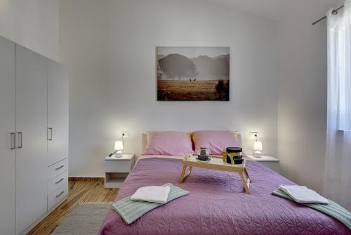 a bedroom with a purple bed with a table on it at Villa Lu in Vodnjan