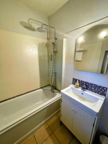 a bathroom with a sink and a bath tub and a sink at Le Manoir du Raveyron in Vallon-Pont-dʼArc