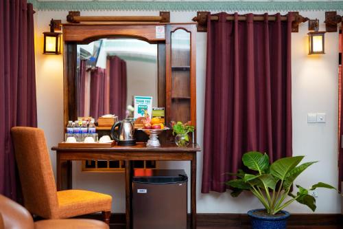 a mirror in a room with a table and a chair at Hello Cambodia Hotel in Phumi Ta Phul