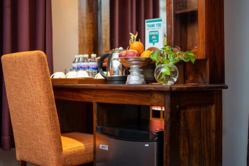a wooden table with a counter with fruit on it at Hello Cambodia Hotel in Phumi Ta Phul
