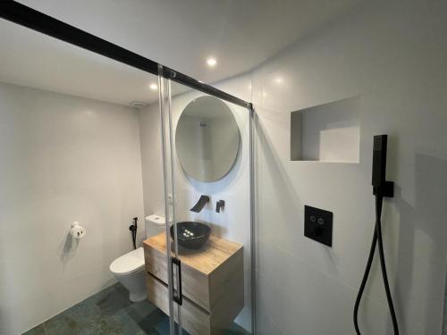 un baño con inodoro y espejo en Apartament Cervantes, en Palamós