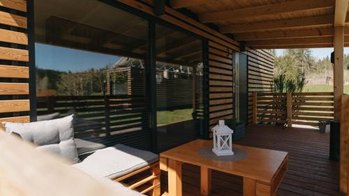 a screened in porch with a couch and a table at Woodbox Istebna in Istebna