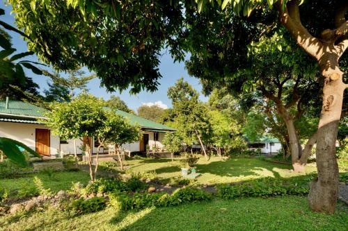 a house with a yard with trees and grass at Kamunjila Lodge in Livingstone