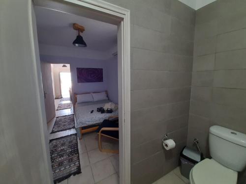 a bathroom with a toilet and a room with a table at Symbligates rocks in Kalymnos