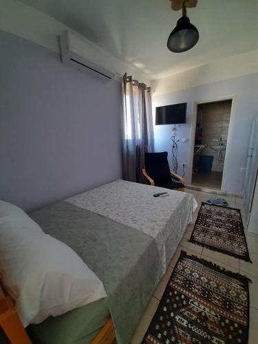 a bedroom with a bed and two rugs on the floor at Symbligates rocks in Kalymnos