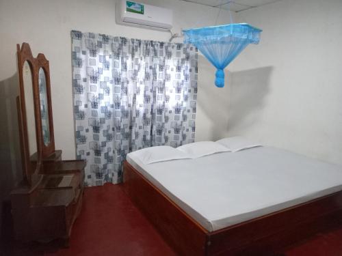 a bedroom with two beds and a window with a curtain at Senasuma Holiday Bungalow Anuradhapura in Anuradhapura