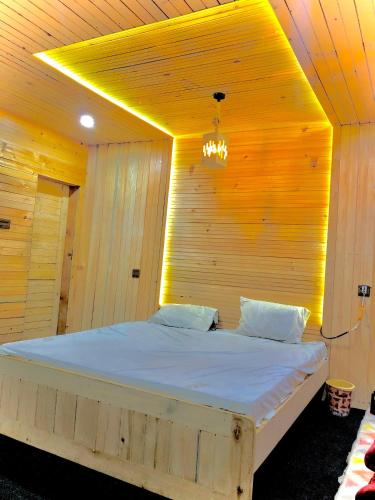 a bedroom with a large bed with a wooden wall at Kumrat valley escapes in Tāl