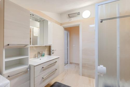 a white bathroom with a sink and a shower at House Horizon in Pazin