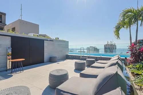 a patio with seating and a view of the ocean at SkyLux Rio Luxo com Garagem in Rio de Janeiro