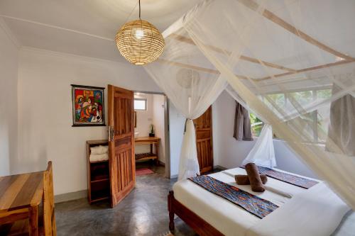 a bedroom with a canopy bed and a desk at Kamunjila Lodge in Livingstone