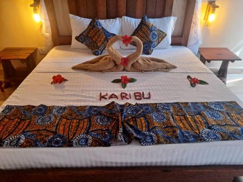 a bed with two swans on top of it at DOGO E ILARIA Bed & Breakfast in Nungwi