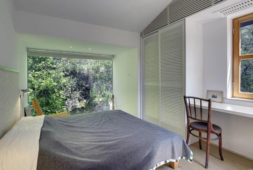 a bedroom with a bed and a chair and a window at Villa Mala Villa in Krnica
