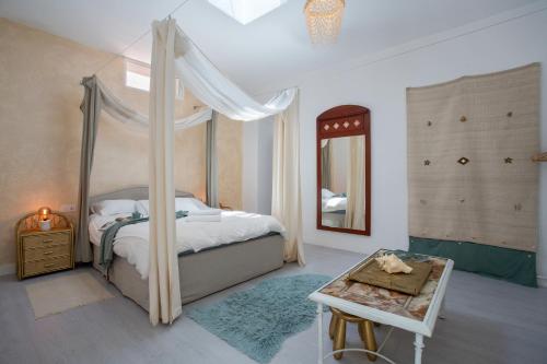 1 dormitorio con cama con dosel y espejo en Casa Penchita, en Santa Cruz de Tenerife