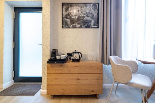 a wooden dresser in a room with a chair and a window at Apartmany CASA MIA in Bojnice