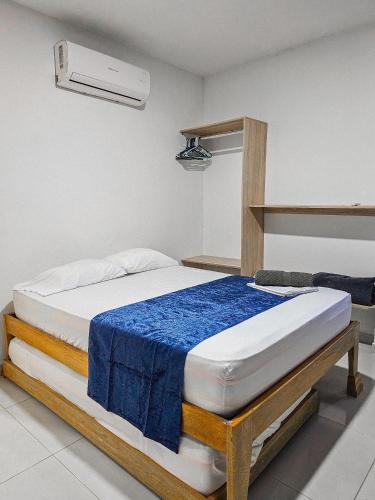 a bedroom with a bed with a blue blanket on it at Casa Playa Boquilla in Cartagena de Indias