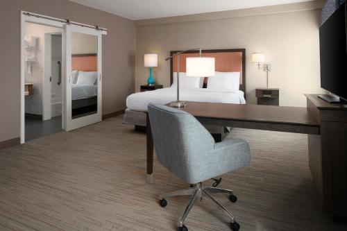 a hotel room with a desk and a bed at Hampton Inn & Suites Yonkers - Westchester in Yonkers