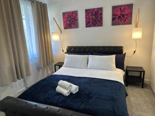 a bedroom with a bed with two towels on it at Stylish 2 Bedroom Flat Slough in Slough