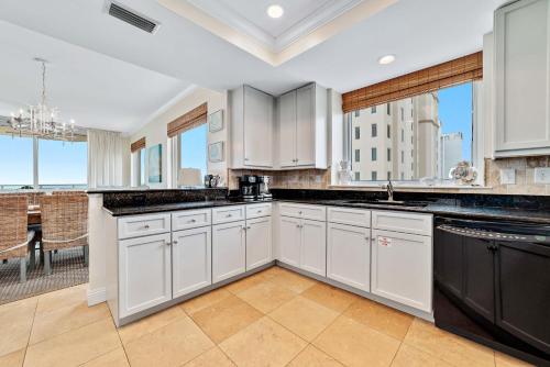 una cucina con mobili bianchi e una grande finestra di Indigo Unit 1406e a Pensacola