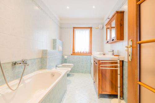 Un baño con bañera, inodoro y lavabo. en CASA VIDI, en Madonna di Campiglio