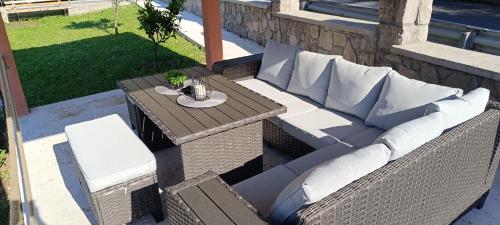 a patio with a couch and a table and chairs at Apartman Luka in Trojica