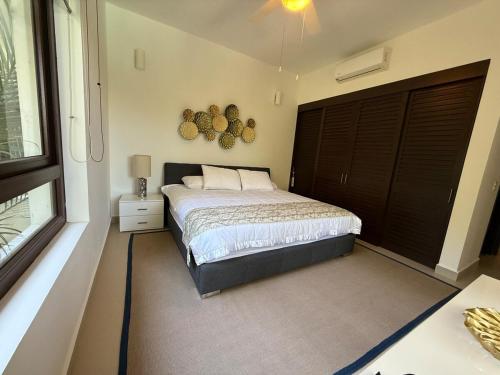 a bedroom with a bed and a large window at Selva Tulum - HiveNB in Tulum