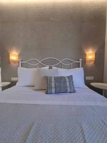 a bed with two pillows on it with two lamps at Grammeno Seaside Studios in Palaiochóra