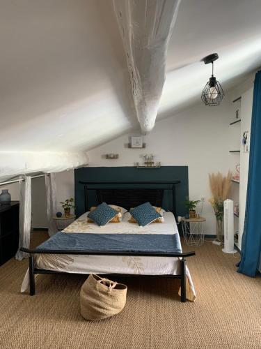 une chambre avec un grand lit avec des oreillers bleus dans l'établissement Laudacieuse, à Cazouls-lès-Béziers
