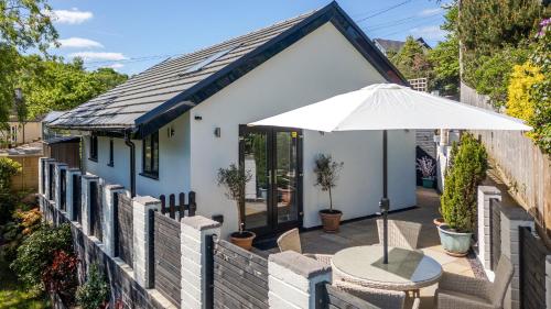a patio with a table and an umbrella at Finest Retreats - Torino Lodge in Newbridge