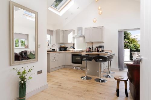 a kitchen with white cabinets and black stools in it at Finest Retreats - Torino Lodge in Newbridge