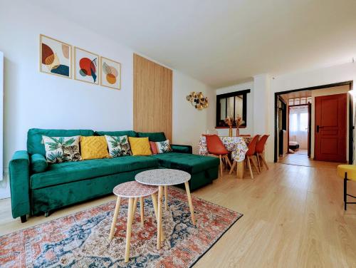 un salon avec un canapé vert et une table dans l'établissement Chic and spacious appartment with balcony, à Fontenay-aux-Roses