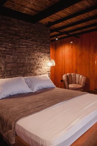 a bedroom with a large bed and a chair at Oasis Barichara in Barichara
