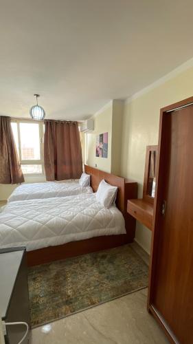 a bedroom with a large bed and a window at ALADDIN PYRAMIDS View in Cairo
